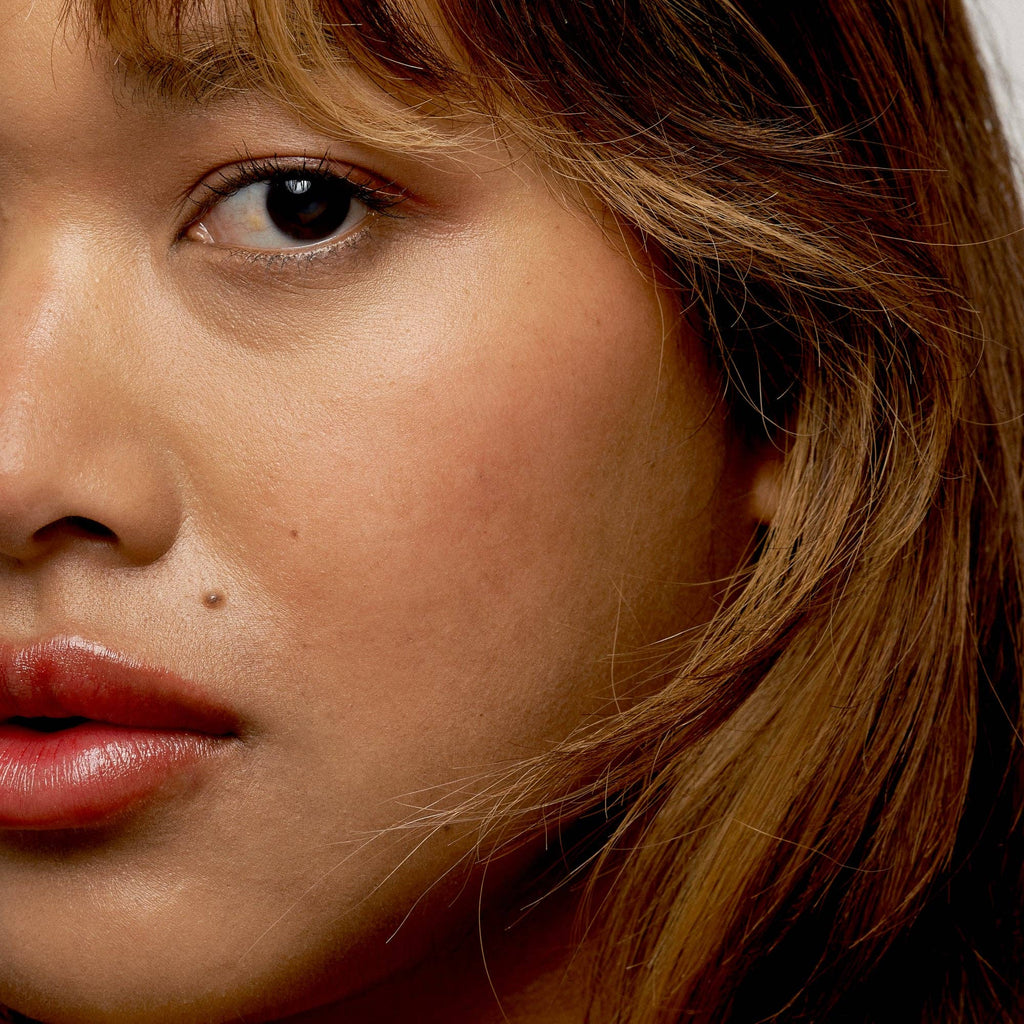 Close-up of a person with brown hair and pink lipstick