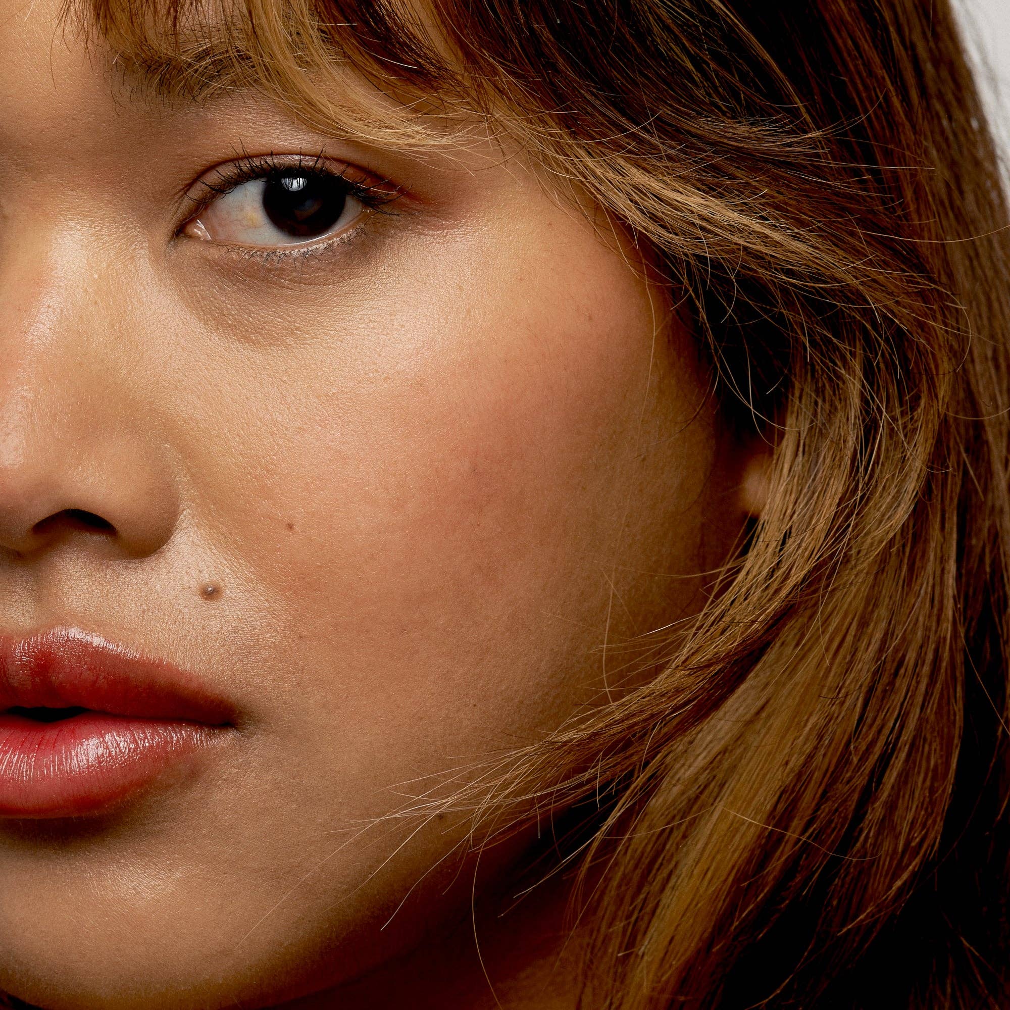 Close-up of a person with brown hair and pink lipstick